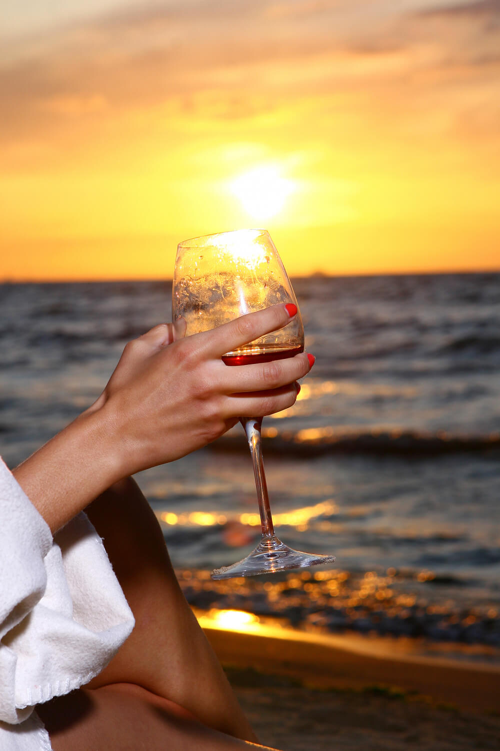 beautiful-young-woman-drinking-wine-beach